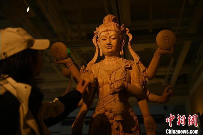 圖為季茂杰觀察自己創(chuàng)作的敦煌木雕。李亞龍 攝</p>
<p>