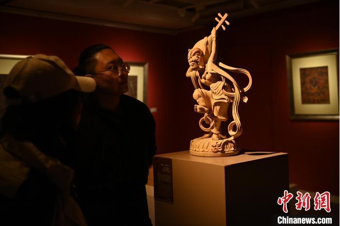 圖為季茂杰向參觀者介紹自己創(chuàng)作敦煌木雕的過程。李亞龍 攝</p>
<p>